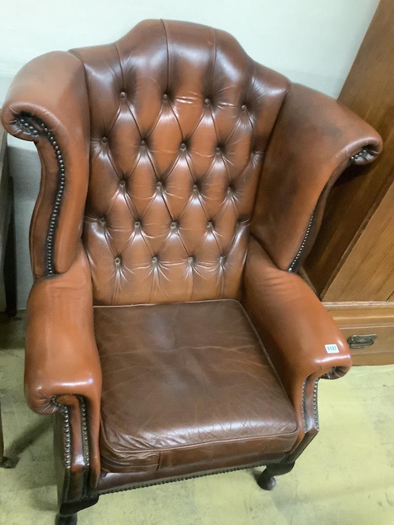 A buttoned burgundy leather wing armchair, width 86cm, depth 80cm, height 110cm